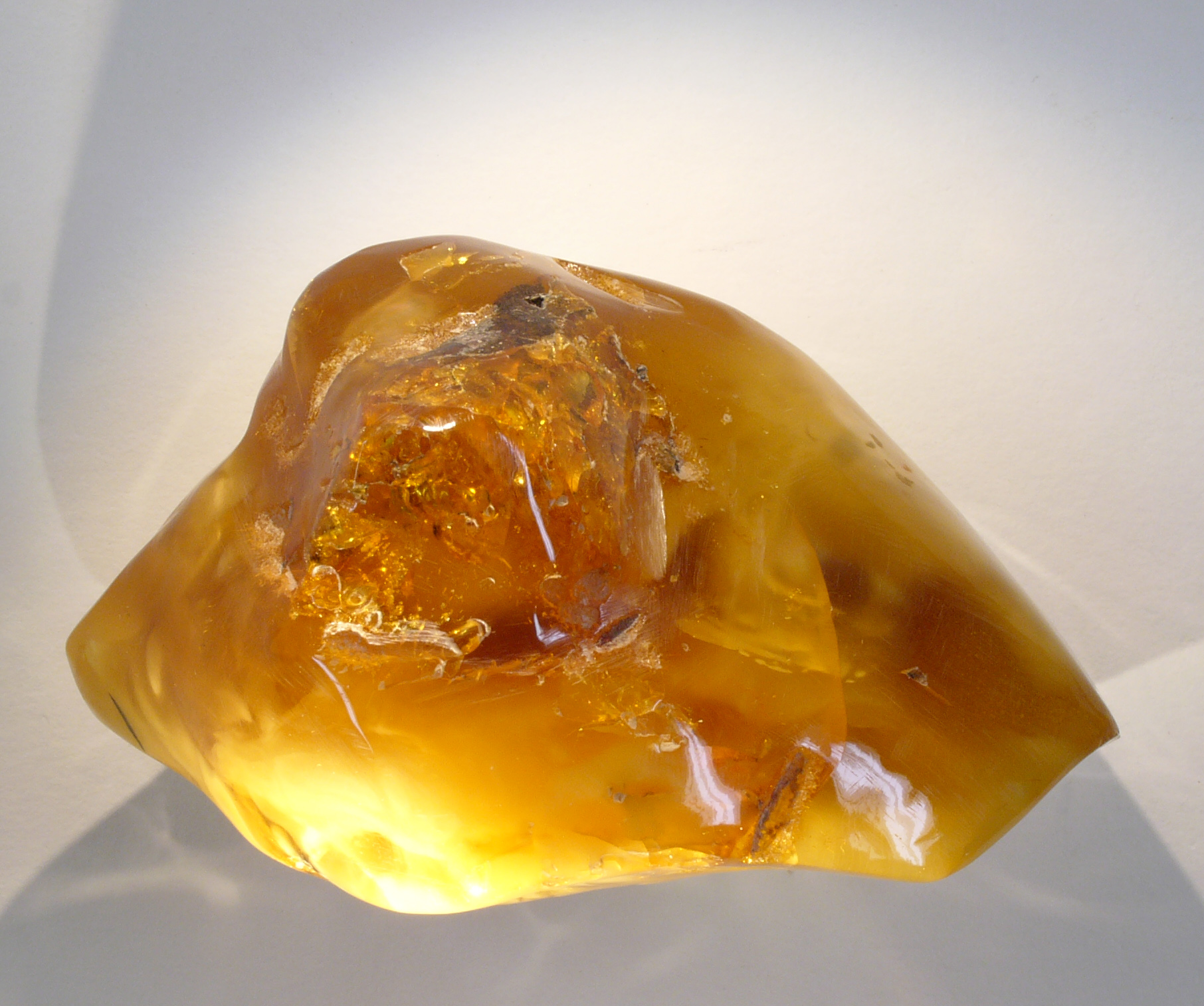Morceau d'ambre poli, résine fossile translucide de couleur miel. Photo Hannes Grobe, Wikimedia Commons, CC BY 3.0.